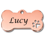 Rose gold bone-shaped pet tag with 'Lucy' engraved and a paw print cutout on a white background